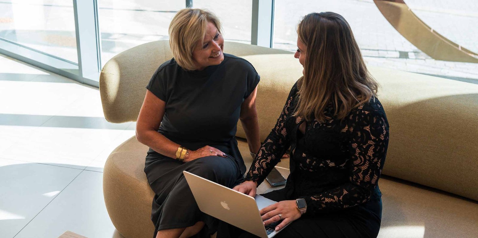 Two colleagues working together on a sofa